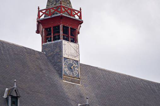 Sundial above the clock on a spire of the town hall of Damme, Belgium.