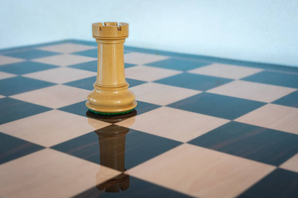 White rook on a chess board Wooden chess piece. White rook on a chess board, symbol of a tower of strength. chess rook stock pictures, royalty-free photos & images