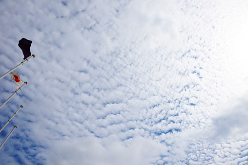 Japanese flag fluttering in the wind against Cirrocumulus cloud with copy space.