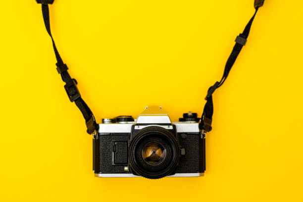 istock Retro camera with analog film on yellow background 1348019806