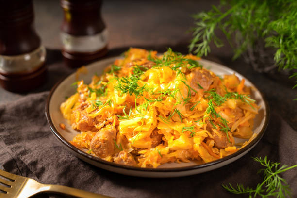 istock Braised cabbage. Stewed cabbage or bigos with turkey meat in a ceramic plate on a dark background. Traditional Polish dish 1348020678
