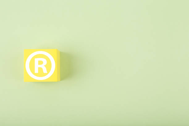 istock Trademark sign on yellow toy cube on bright pastel green background with copy space 1348024082