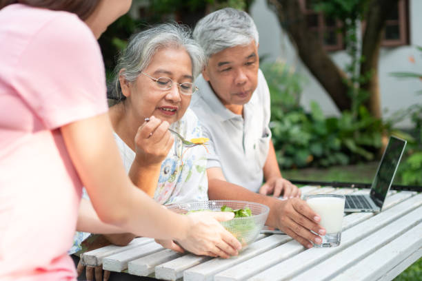 不幸なアジアの先輩女性拒食症と食事にノーと言う、高齢者は家族と一緒に住んでいて、介護者は食欲を与えようとし、老婦人は食欲を与え、ヘルスケアと高齢の介護者の概念 - old senior adult women tired ストックフォトと画像