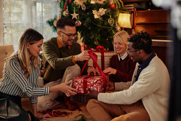 Cheerful friends opening Christmas present stock photo