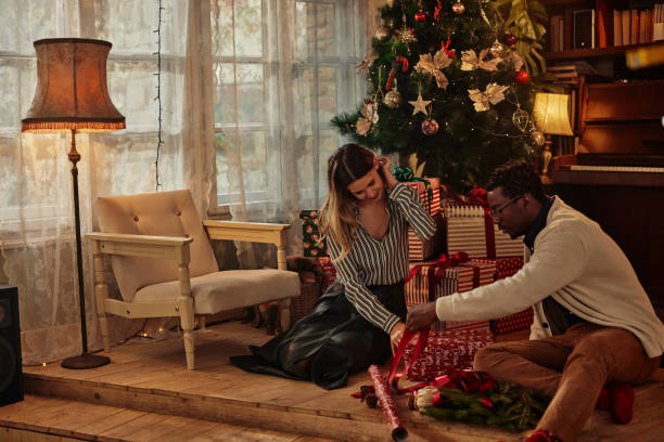 istock Couple opening a christmas present together 1348025322