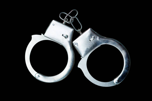 istock handcuffs isolated on a black background 1348025429