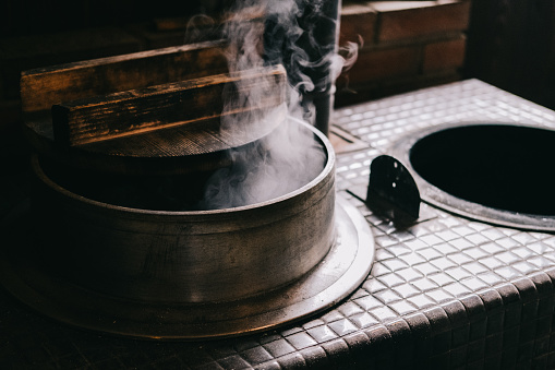A kamado is an apparatus for cooking that encloses a fire when heating foodstuffs.