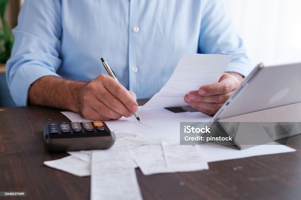 Man calculating personal expenses at home Tax Stock Photo
