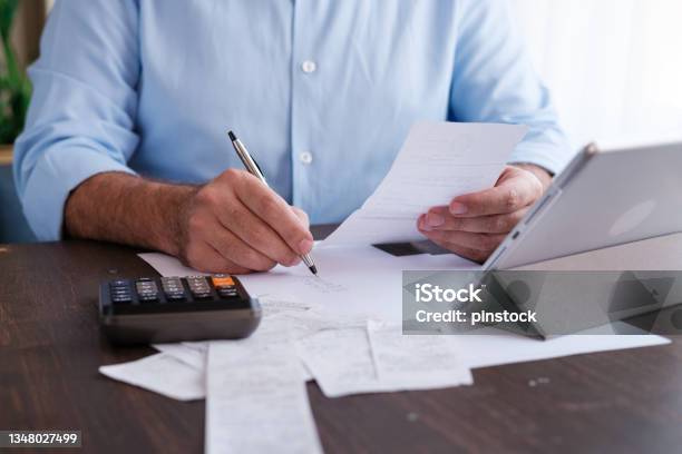 Man Calculating Personal Expenses At Home Stock Photo - Download Image Now - Tax, Accountancy, Tax Form