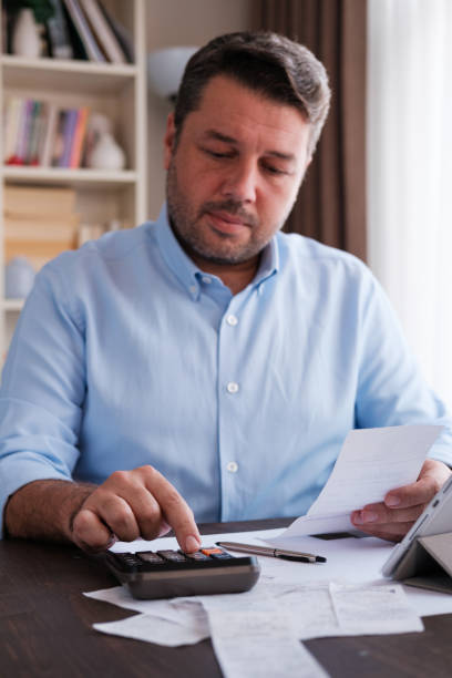 istock Man calculating personal expenses at home 1348027512
