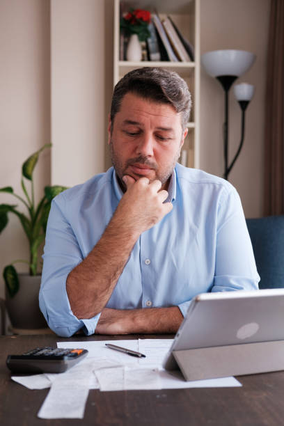 istock Man calculating personal expenses at home 1348027564