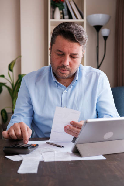 istock Man calculating personal expenses at home 1348027584