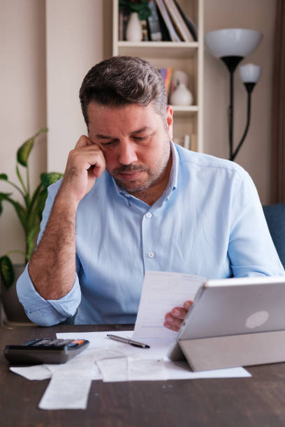 istock Man calculating personal expenses at home 1348027588