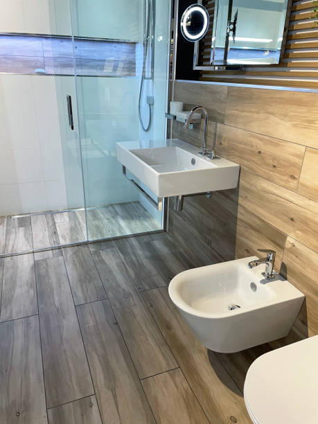 istock Image of Swedish style bathroom suite with white wall hung bidet and toilet, rectangular sink with under hanging chrome towel rail, separate shower cubicle, sliding, panelled glass door, overhead, rectangular power shower, wall hanging directional shower 1348029446
