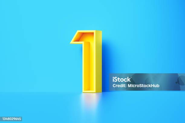 Yellow Number One Sitting On Blue Background Stock Photo - Download Image Now - Number 1, Single Object, Three Dimensional