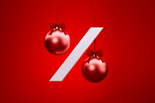 Red Christmas baubles forming percentage sign sitting over red background. Horizontal composition with copy space. Front view. Great use for Christmas Sale concepts.