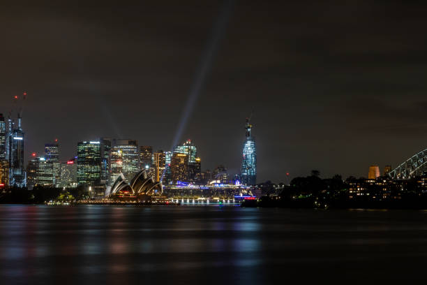 Sydney, Australia - May 29, 2014: Animated images and colourful designs projected onto the sails of the Sydney Opera House for the Vivid Sydney festival at Sydney Harbour. Crowded Opera Bar in the foreground.