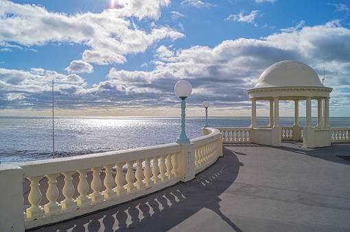 A view of Bexhill Seafront taken from the De La Warr Pavilion on a sunny but cloudy autumn day. One of the pavilion cupolas is seen in the midground.
