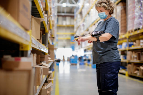 female warehouse worker checking goods on racks with wearable bar code reader - bar code reader wireless technology computer equipment imagens e fotografias de stock