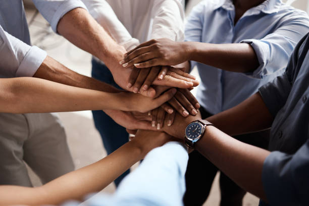 istock Shot of a group of unrecognizable businesspeople stacking their hands at work 1348038422