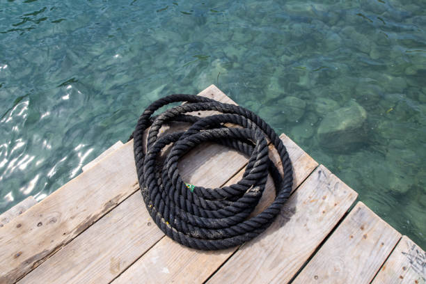 istock Rolled up black ropes on a boating dock yard in Spain 1348038624