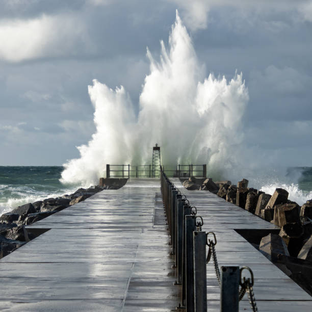 faro en el muelle de norre vorupor durante la tormenta y el mar pesado, jutlandia, dinamarca - lighthouse beacon north sea coastal feature fotografías e imágenes de stock
