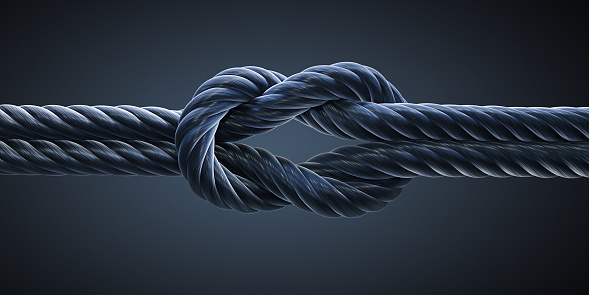Reef knot, Square knot of black rope isolated on dark background