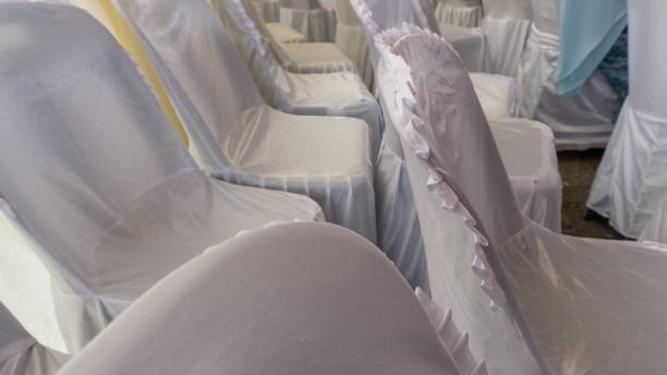 istock Empty white chairs at the wedding day. wedding ceremony chair decoration, covered with white fabric 1348045982