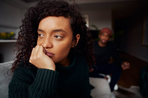 primer plano de una mujer de raza mixta ignorando a su novio negro mientras pelea en el sofá en un apartamento moderno - couple african descent africa human relationship fotografías e imágenes de stock