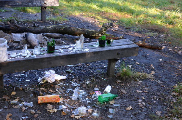 vandalismus im park. nach der nachtparty blieben nur zertrümmerte glasalkoholflaschen auf der bank. der obdachlose schläft und lebt außerhalb der stadtscherbe, drogenabhängigkeit, selbstbeherrschung - dirty bench empty park stock-fotos und bilder