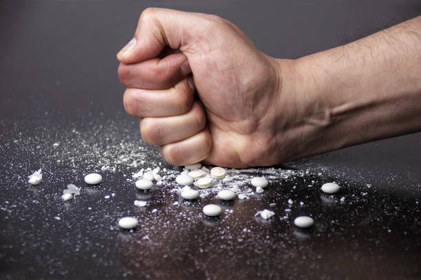hand zerkleinernde weiße pillen - narcotic teenager cocaine drug abuse stock-fotos und bilder
