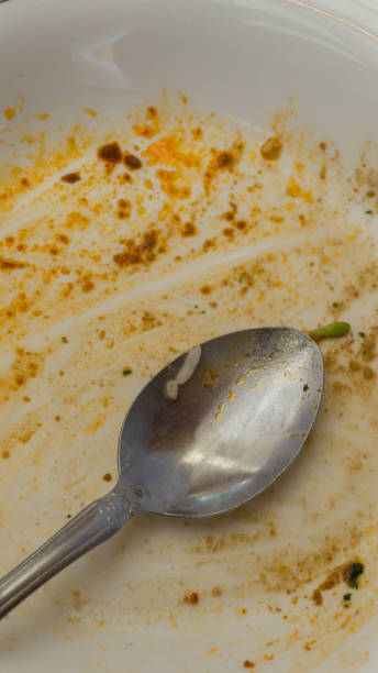 istock Empty and dirty plate with metal spoon 1348046402