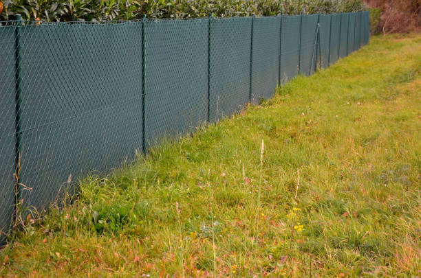 il tessuto ombreggiante sulla recinzione metallica crea uno spazio privato e in un attimo si ha una recinzione opaca da fastidiosi vicini e viste dalla strada, cantiere - fence formal garden gardening ornamental garden foto e immagini stock