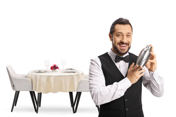 istock Barman with a cocktail shaker in front of a restaurant table 1348047410