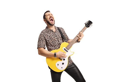 Cool young man playing an electric guitar and singing isolated on white background