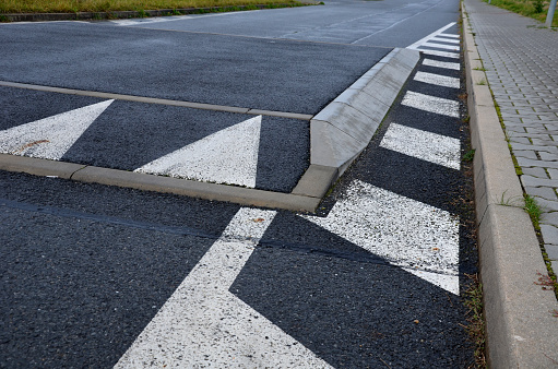 a regular square raised above the level of the asphalt road beveled on all sides. overcoming an obstacle means slowing down the vehicle and thus increasing safety in the residential area near the school, kindergarten