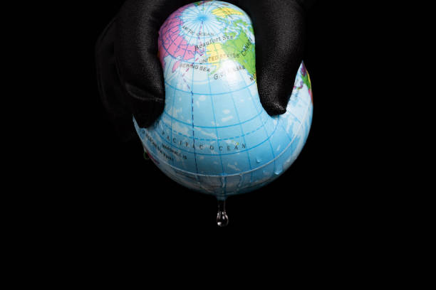 istock squeezing a globe and the last bit of water dropping down concept of human overusing the water resource 1348049102