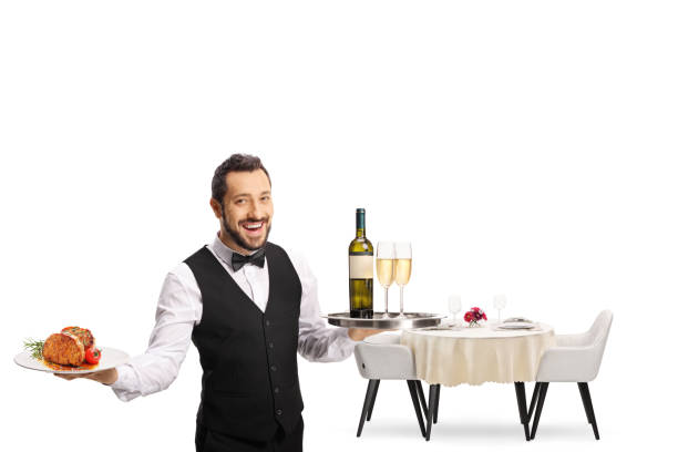 istock Server holding a plate with steak and a tray with wine and a restaurant table behind 1348049655