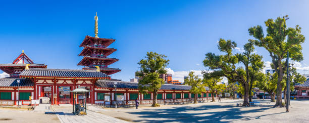 Japan Pagoda overlooking tranquil temple courtyard panorama Shitennoji Osaka The ornate five storey pagoda overlooking the entrance to Shitennoji Temple in the heart of Osaka, Japan’s vibrant second city. shitenno ji stock pictures, royalty-free photos & images