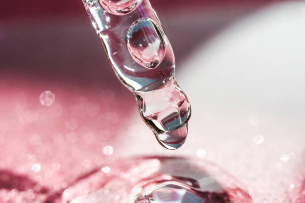 istock Cosmetic pipette with a pink on dark background. 1348050295