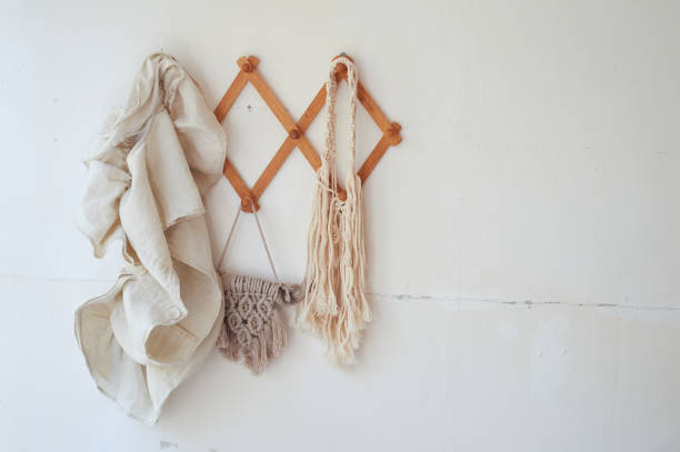 istock Decor items hang on a white wall on a wooden hanger. Macrame , towels. Rustic style 1348050826