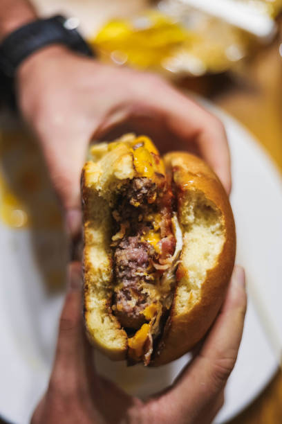 istock full burger with cheddar cheese, bacon and egg on top of a wooden table 1348055466