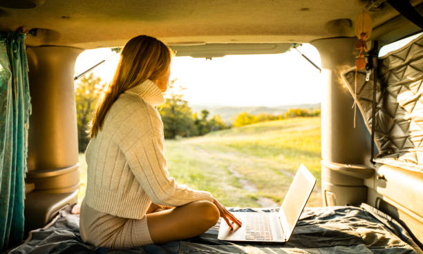 istock Young Woman Enjoying Working on Laptop While on Camping Trip 1348055898