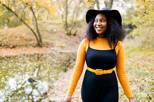 portrait of a beautiful young african american woman smiling and staying outdoors