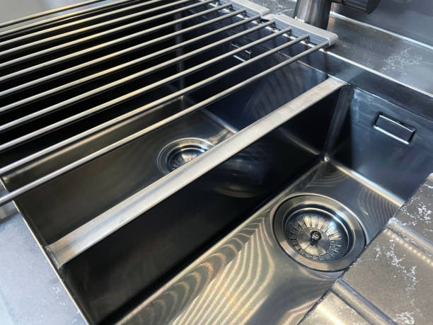 istock Full frame image of modern, rectangular, stainless steel kitchen sink with 1.5 bowl sink and draining board, chrome, single lever monobloc mixer tap, elevated view, focus on foreground 1348059472