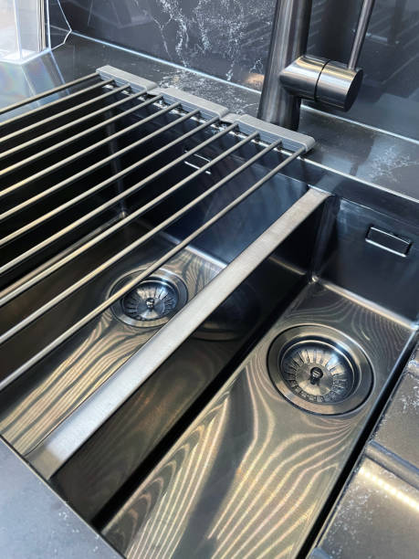 istock Close-up image of modern, rectangular, stainless steel kitchen sink with 1.5 bowl sink and draining board, chrome, single lever monobloc mixer tap, elevated view, focus on foreground 1348059473