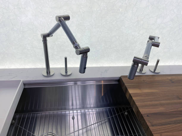 istock Close-up image of a Carbon articulated kitchen mixer tap modern design element in contemporary domestic kitchen stainless steel sink 1348059480