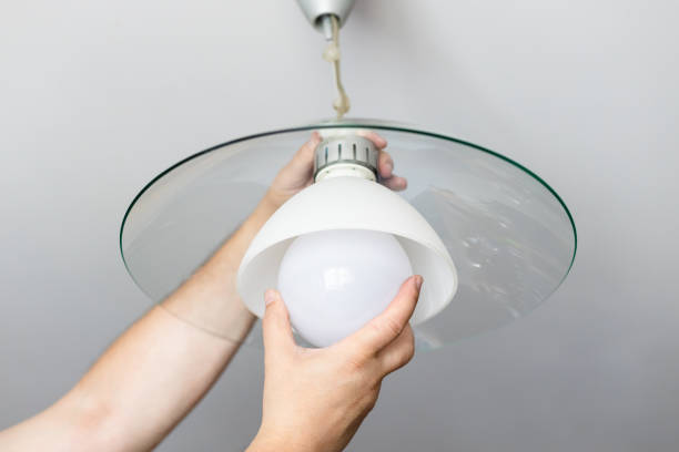 istock man replaces bulb of ceiling lamp 1348060703