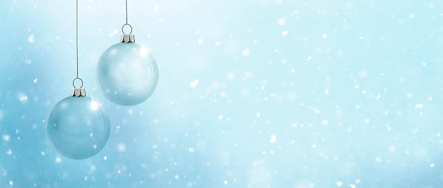 Two glass Christmas balls against a blue background