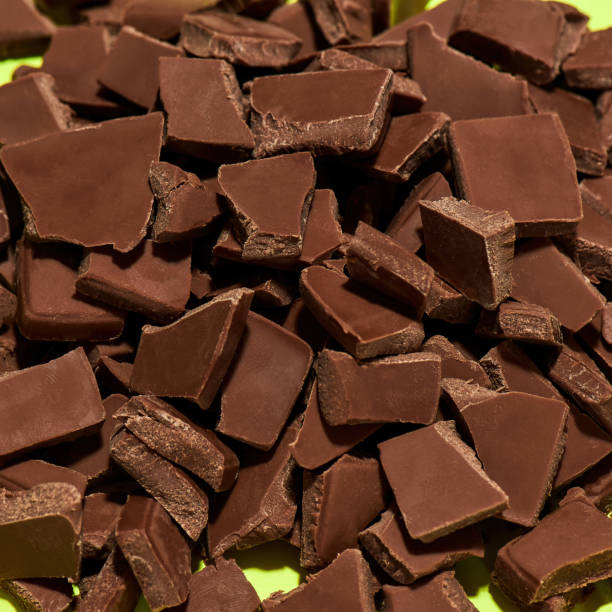istock Closeup of broken, crushed dark chocolate bars stack isolated over green background 1348063652